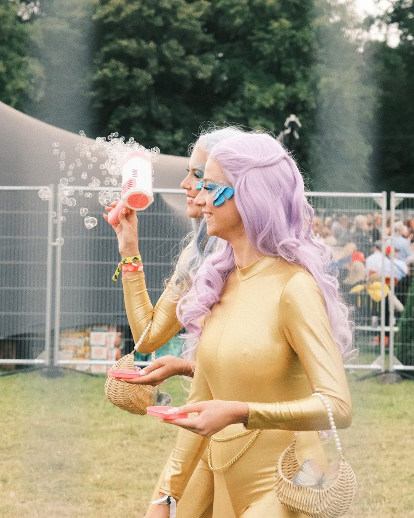 A performer in yellow blowing bubbles