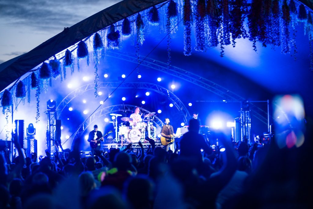 A band on the big top stage under blue light