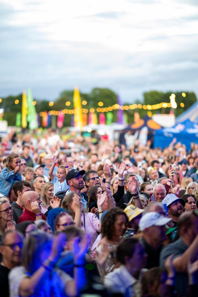 The crowd in daylight with the big top behind