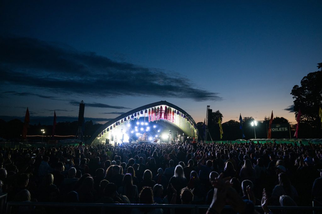 The main stage lit blue against a deep dusk sky